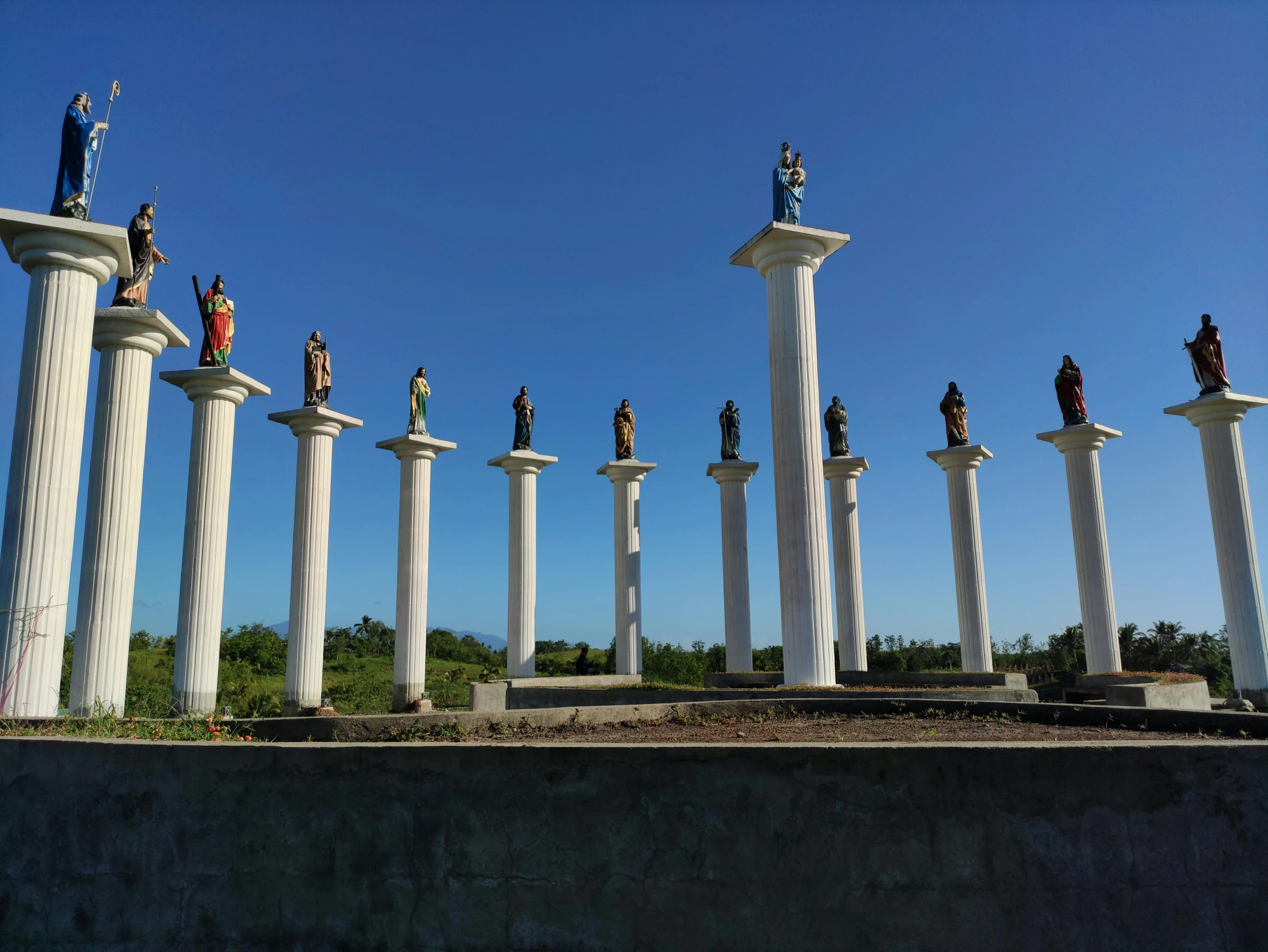 a group of people stand at the top of some very tall white pillars