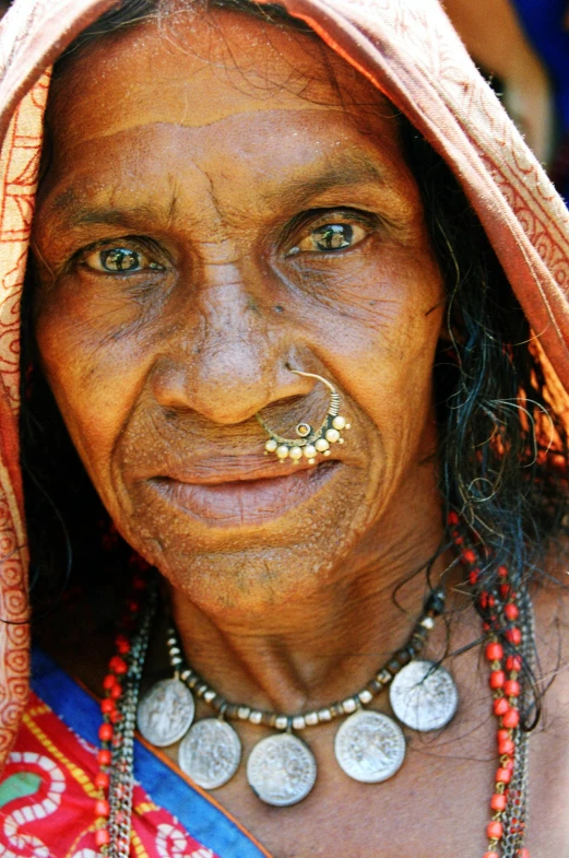 a smiling woman wearing beads and piercings