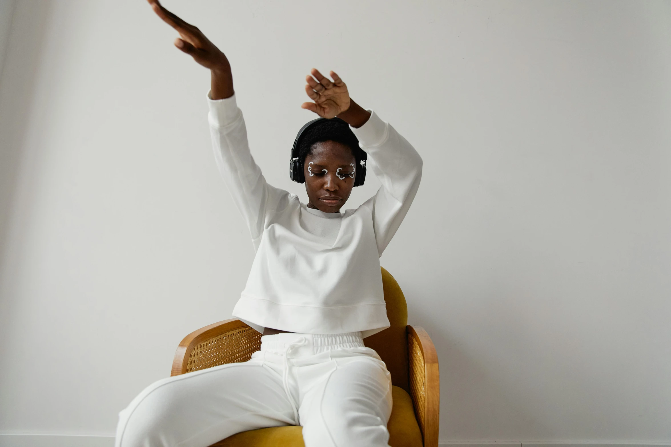 a woman is sitting on a chair holding her arm up