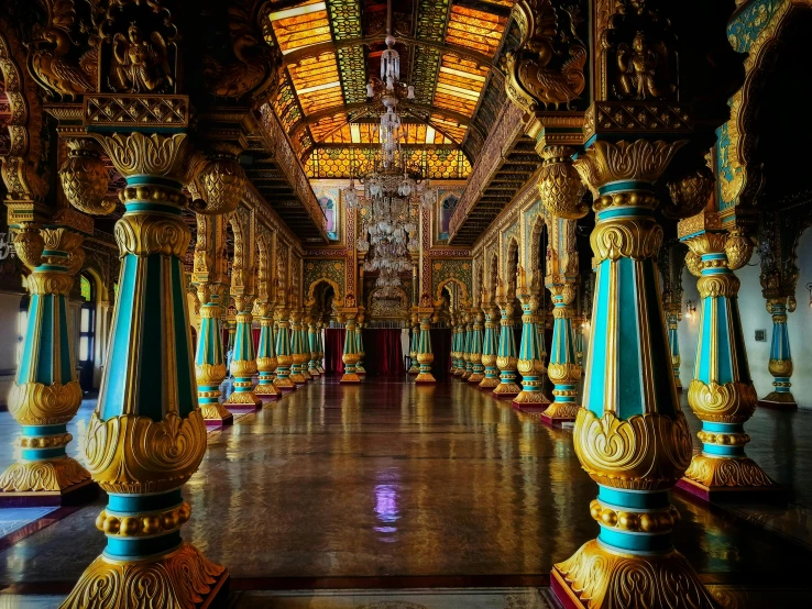 a gold and blue hall with pillars leading to several floors