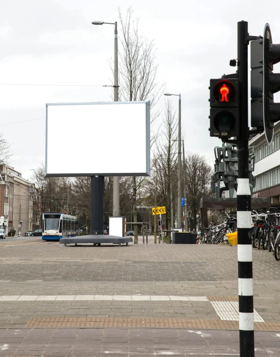 a traffic light sitting next to a white billboard on the street