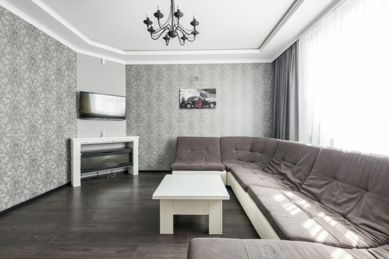 a living room with couch, tv stand, fireplace and a window