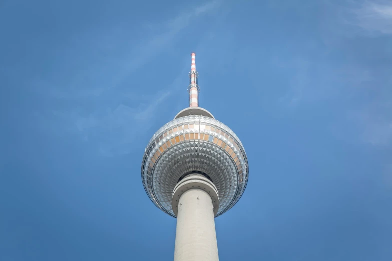 a tall white and red building sitting under a blue sky