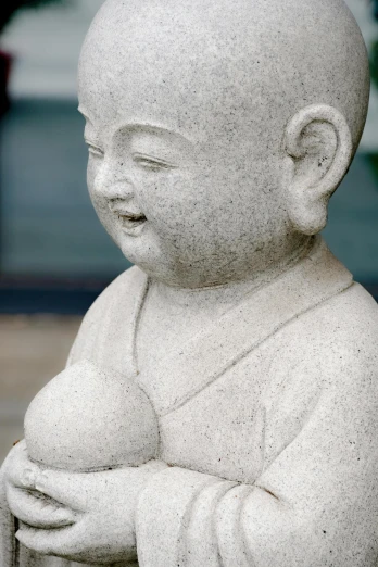 a statue of a baby holding a bottle in his hands