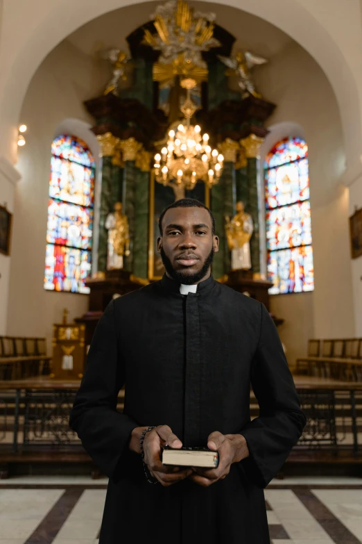 an african american priest is holding his bible in the church