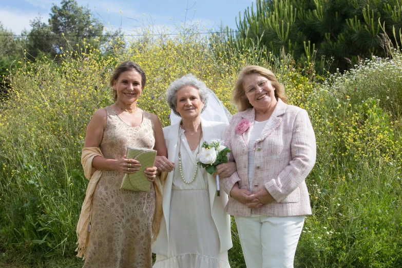 three older ladies standing in a grassy area