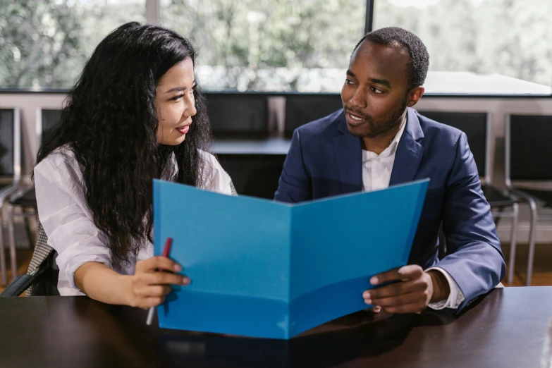 a man and woman looking at a piece of paper