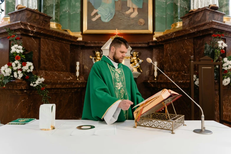 a priest holding an empty book at a mass