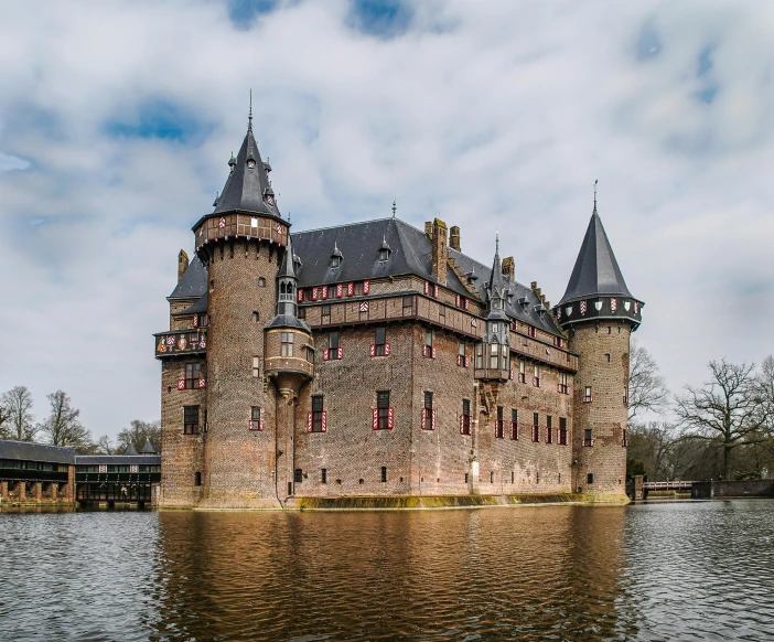 a castle overlooking water with buildings made from brick