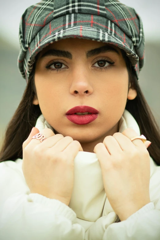 a woman wearing a hat and looking at the camera