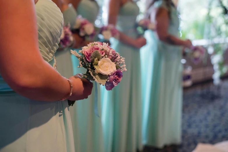 a woman in a wedding dress holds a bouquet in her hand