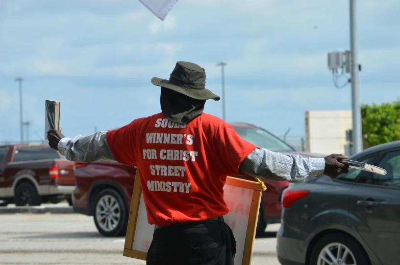 a person standing holding a sign on a city street