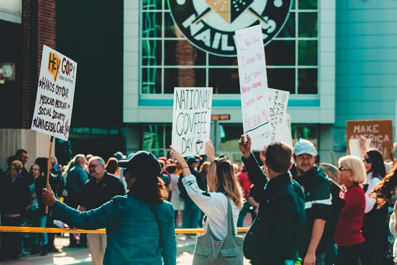 a group of people with signs standing on a street