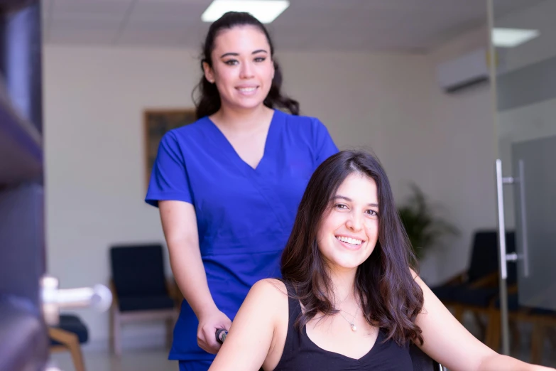 two beautiful young women sitting in a chair