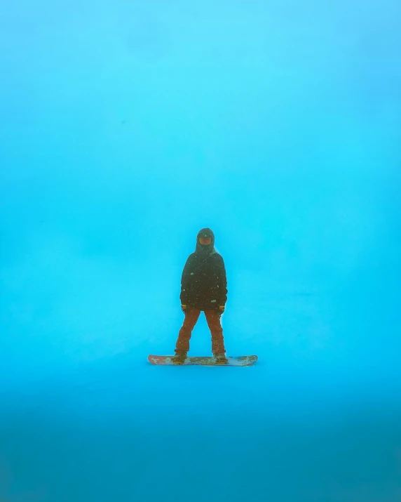 a man standing in the snow on a snow board