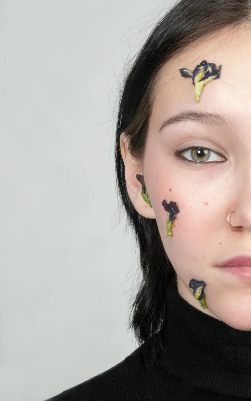 a woman with black paint and flowery eyebrows