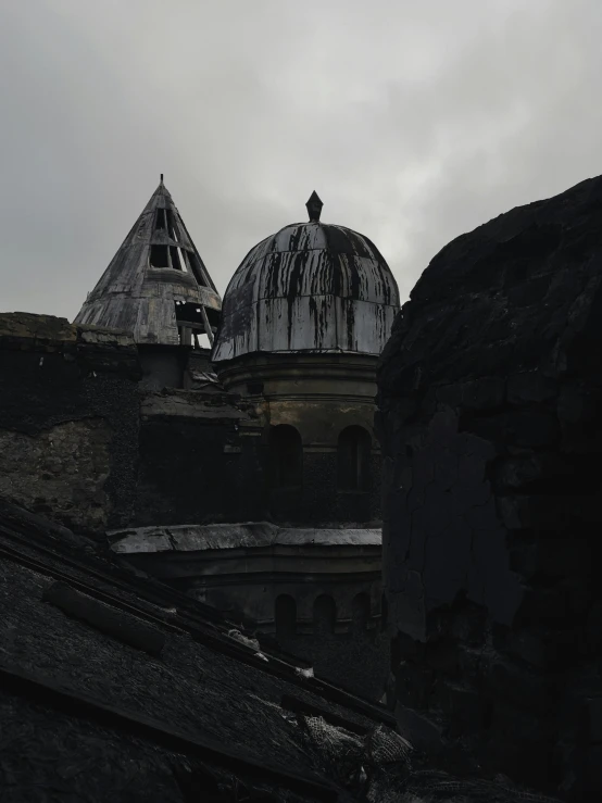 a dark sky view from behind a building in front of a large stone wall