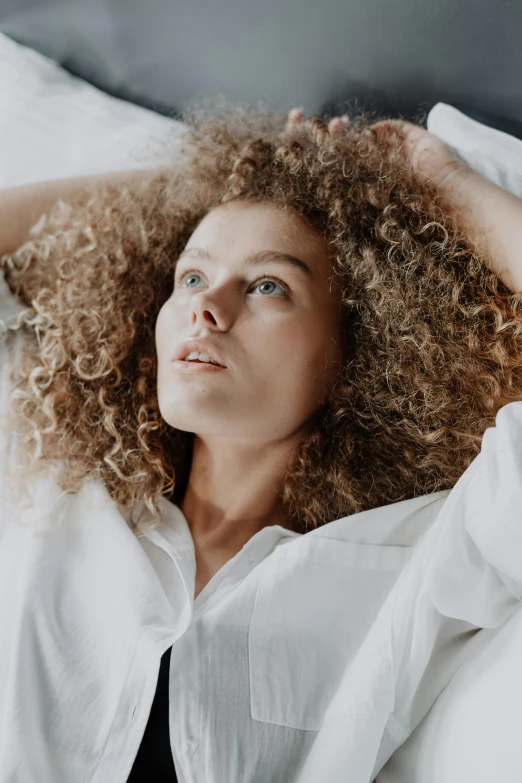 a woman laying on a bed in white