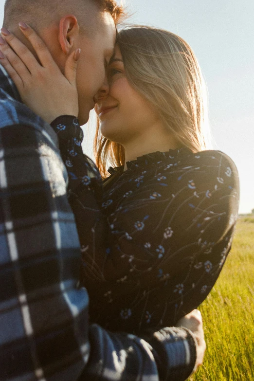 two people are standing in a field with the sun shining on them