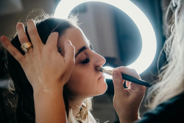 a woman putting lipstick on her lips