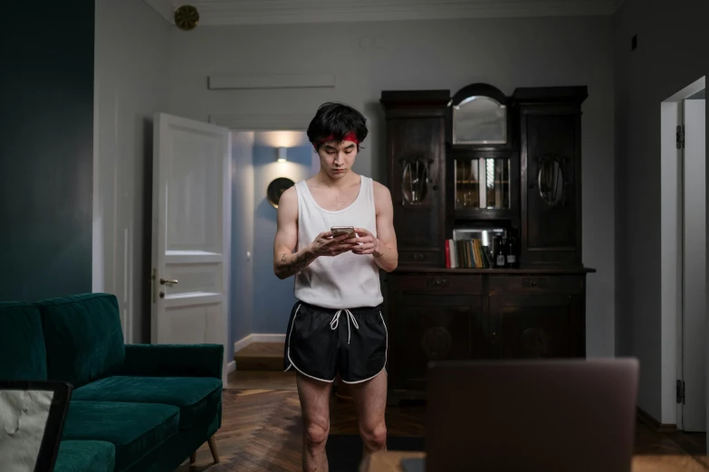 a person wearing shorts and holding an electronic device