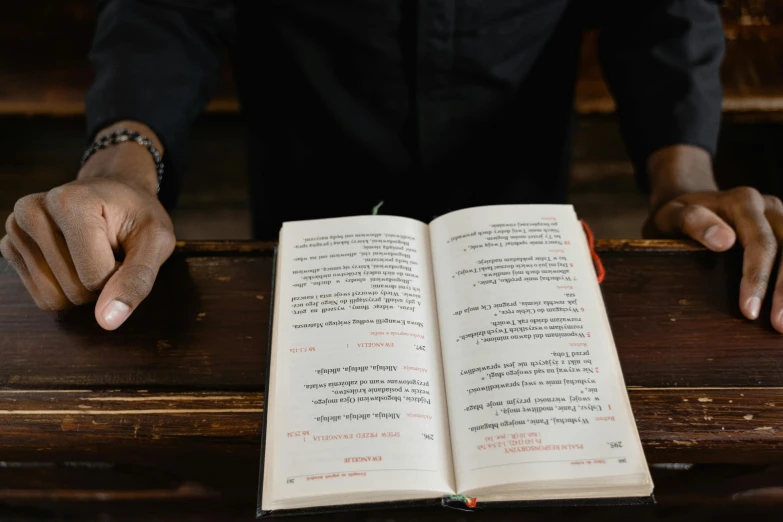 two hands are held open and leaning on an old book