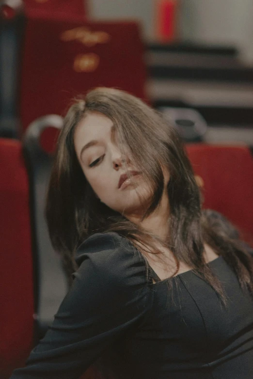 a woman sleeping in a red seat in the middle of an airport