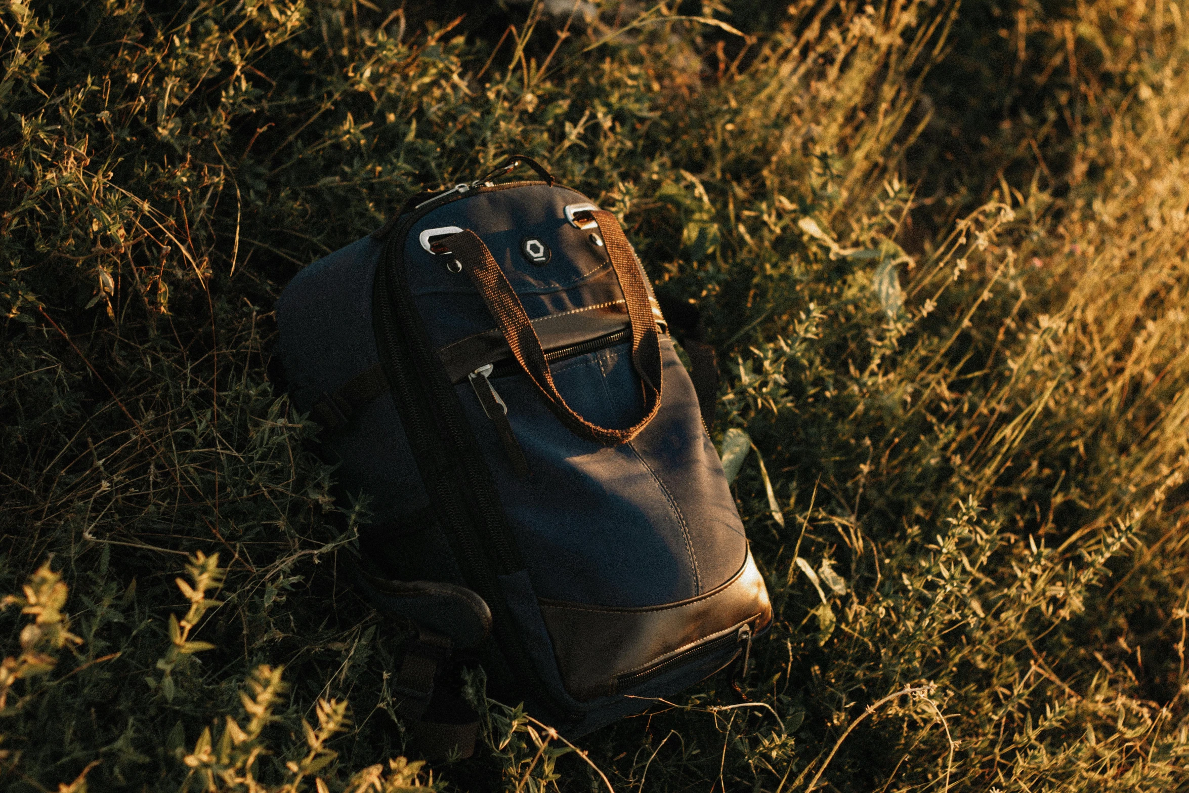 a bag lying in some grass that is laying on the ground