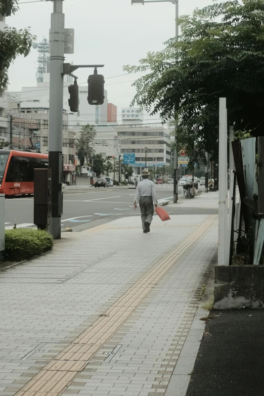 a person walking down the road with a red umbrella