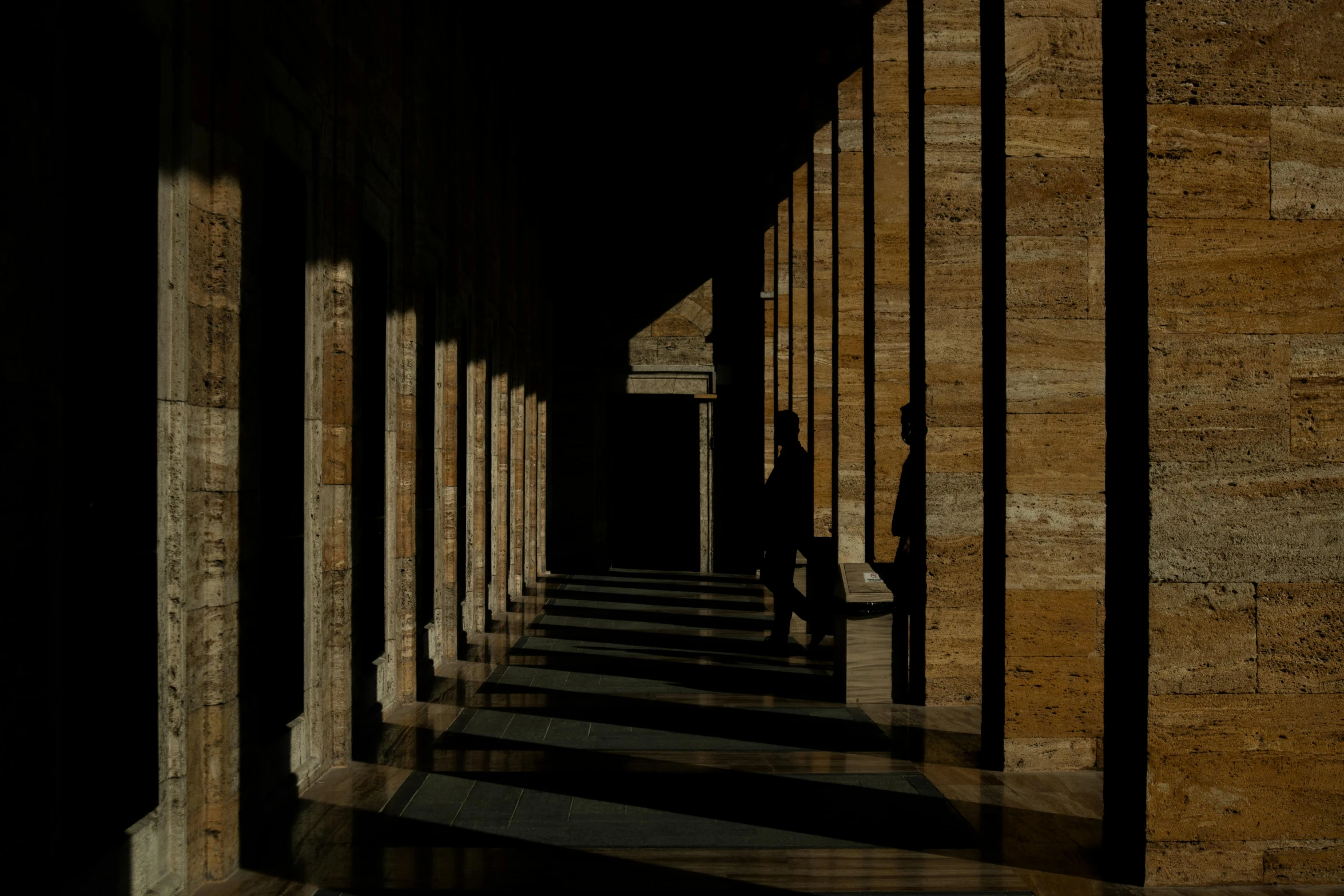 a long hallway with lots of columns and a window