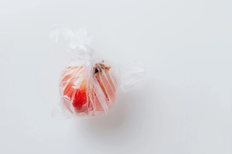 a clear plastic bag with an apple in it