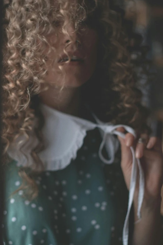 the young woman has curls and holds a string in her hands