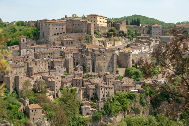 a hill view of an old stone town with several buildings on top