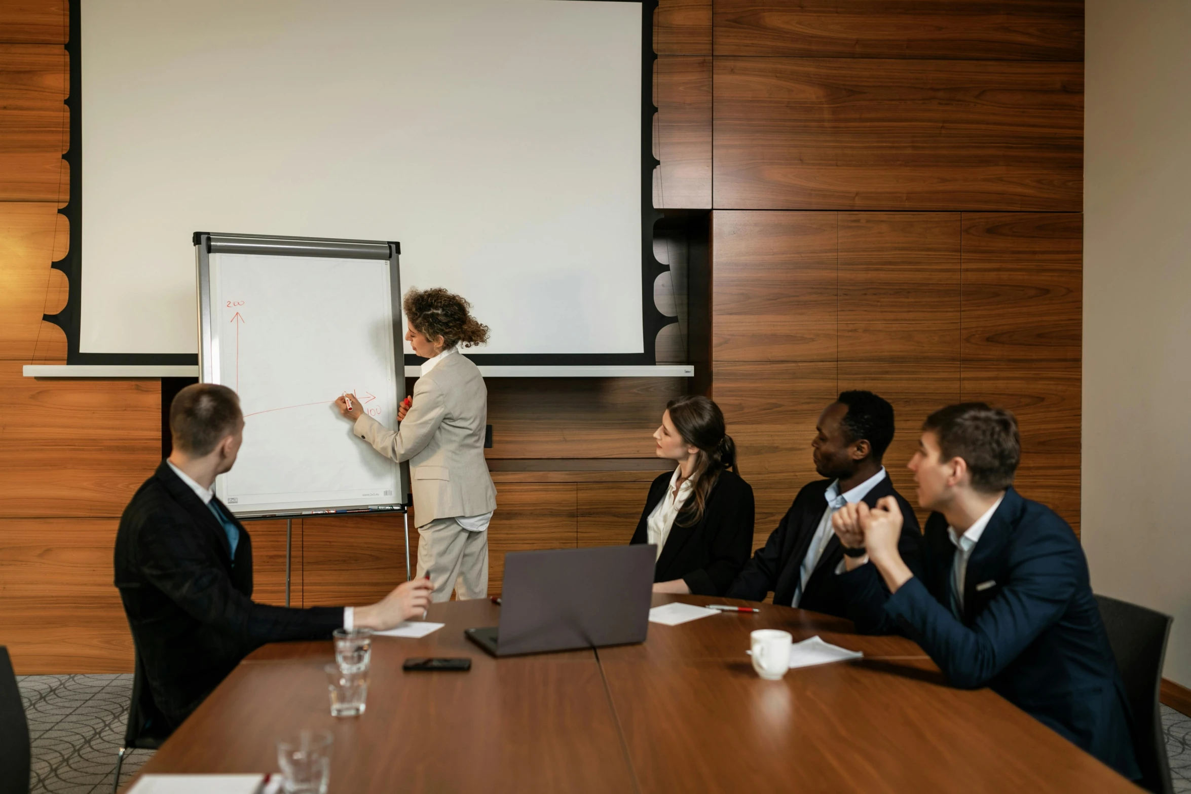 business people sitting at a conference table discussing soing