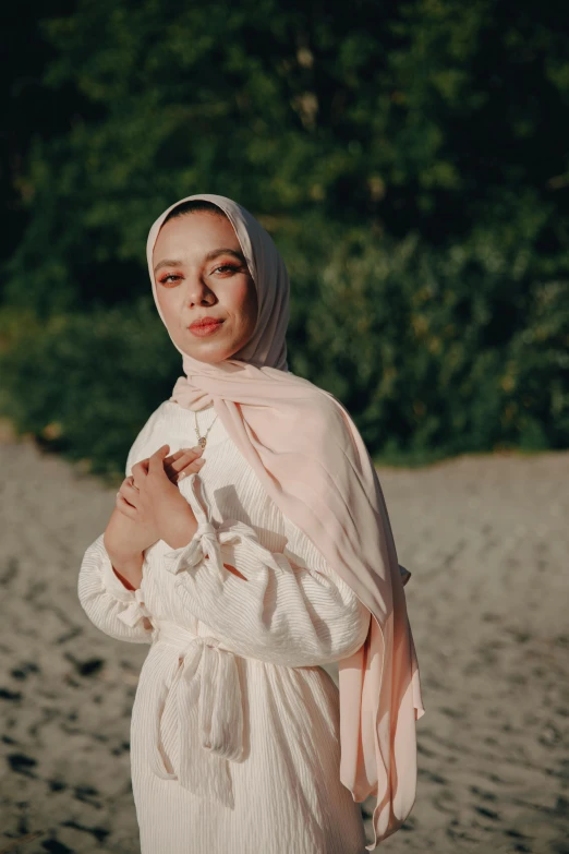 the woman is standing with her hands clasped wearing a shawl