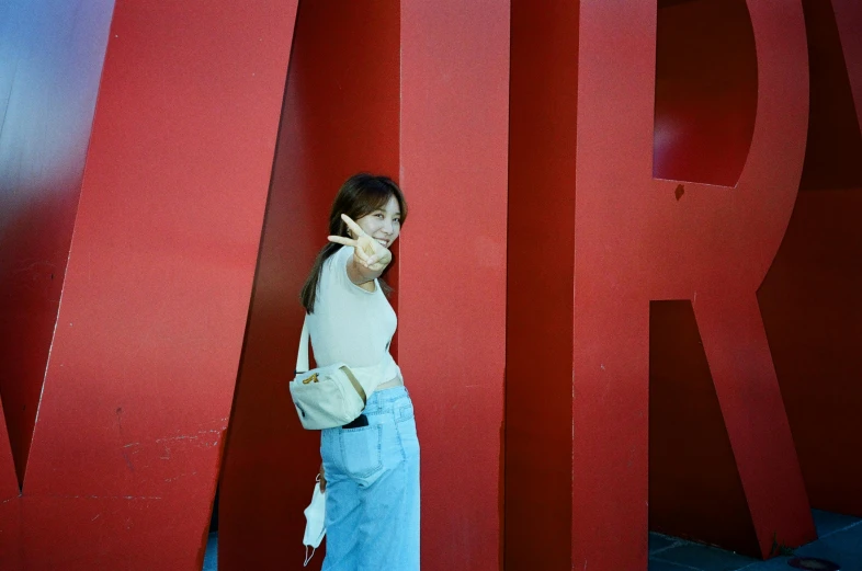 a young lady is standing on a red sign