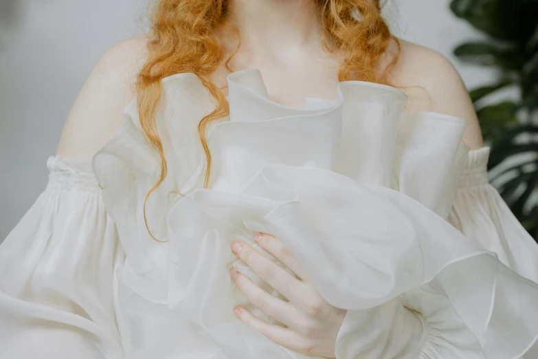 a woman with red hair wearing a white gown