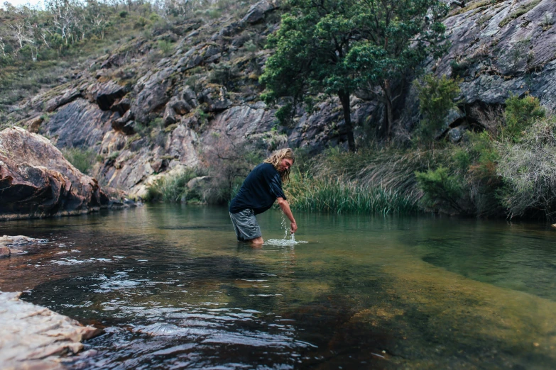 a man in black shirt standing in a river