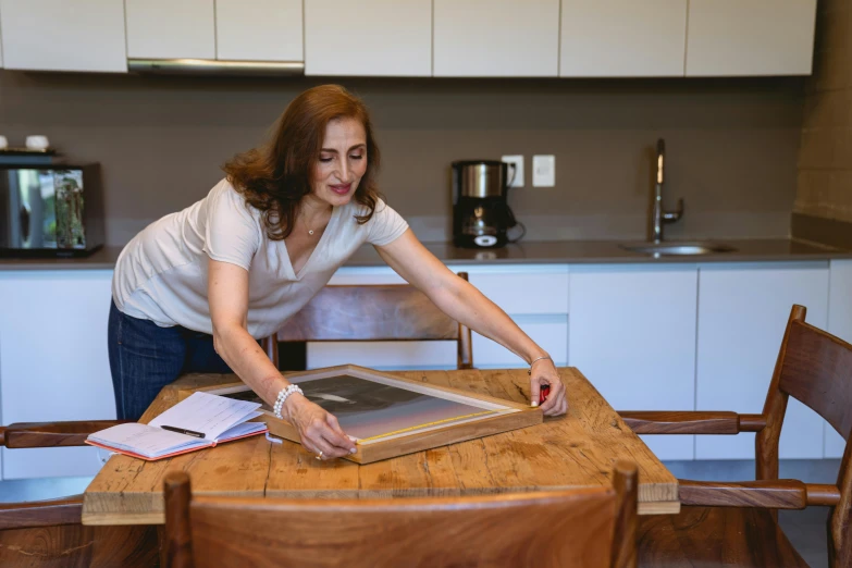 a woman in a kitchen with an open po album