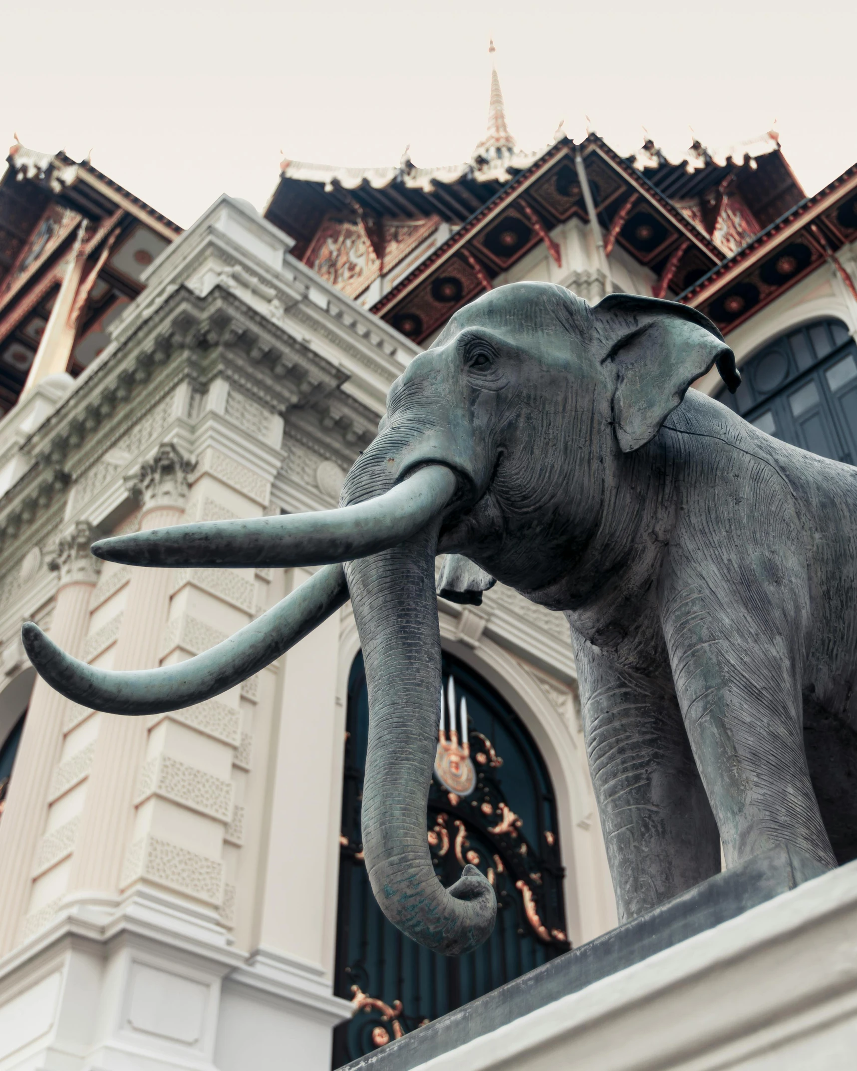 an elephant statue on display in front of a large building