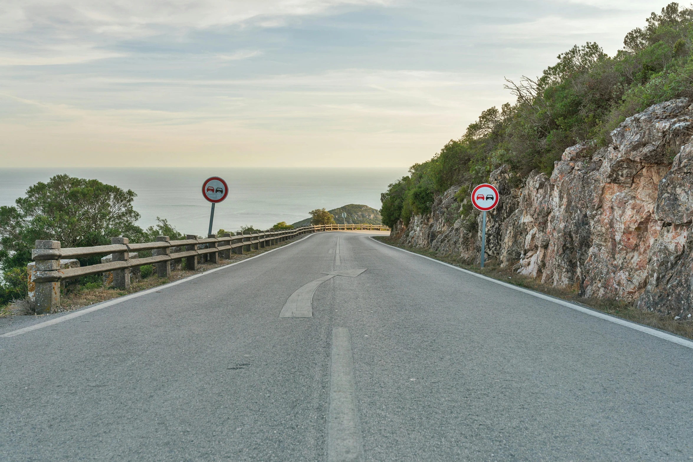 a highway with rock cliffs and two signs