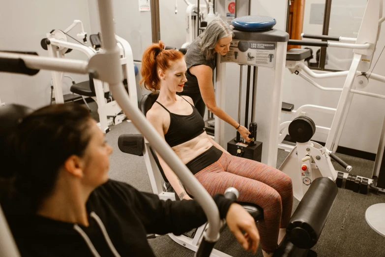 two woman in the gym working out on machines