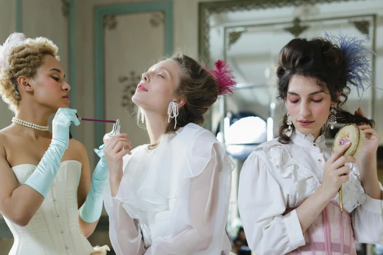 two girls are wearing white dress and one is brushing her teeth