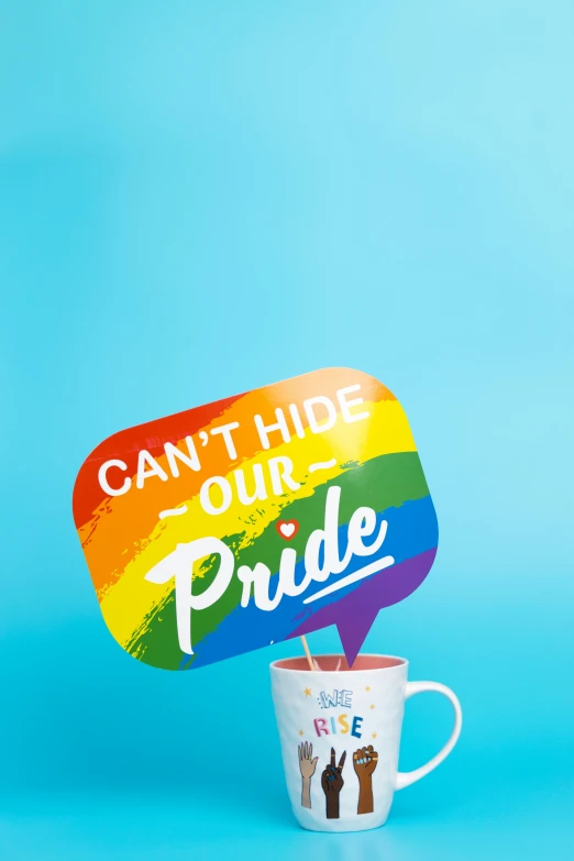 a coffee mug with a rainbow sign and a sticker