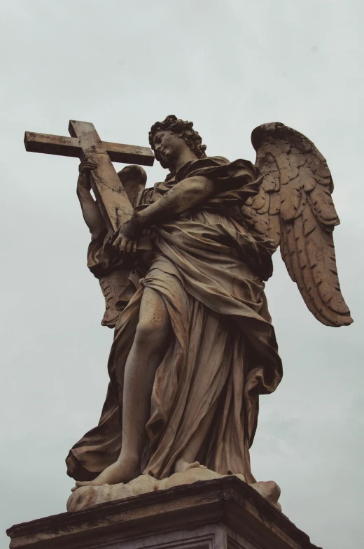 statue of a religious person holding a cross