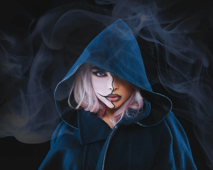 a person in a hoodie surrounded by smoke