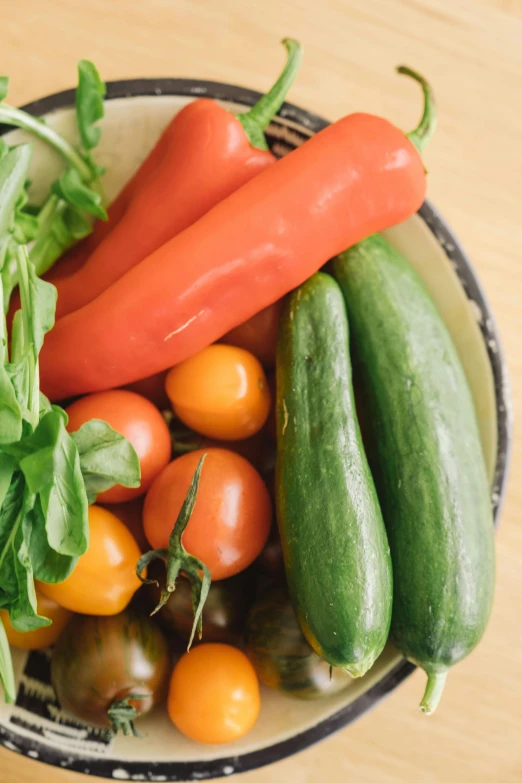 some fruits and vegetables sit in a bowl