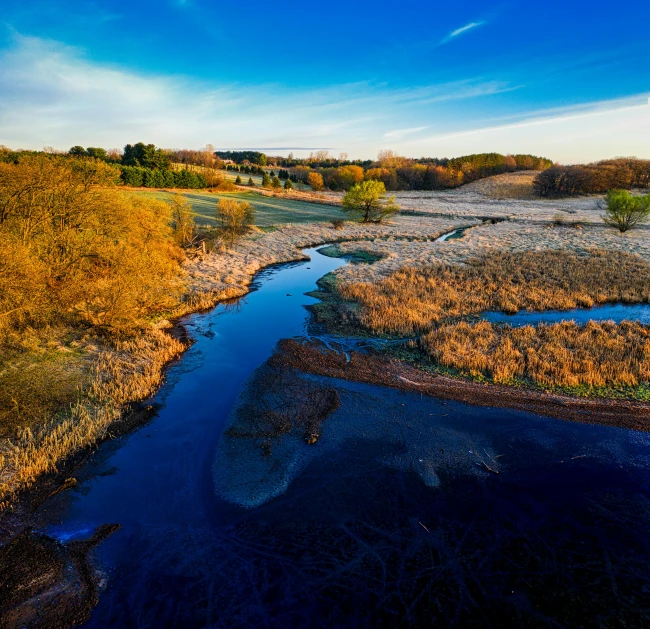 a small river is running through a green and brown landscape