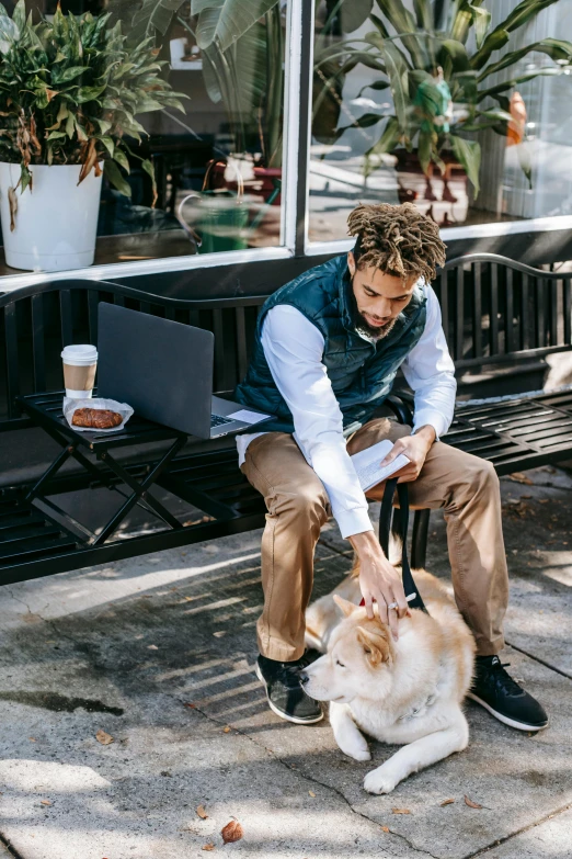 a man petting his white cat while sitting on the bench