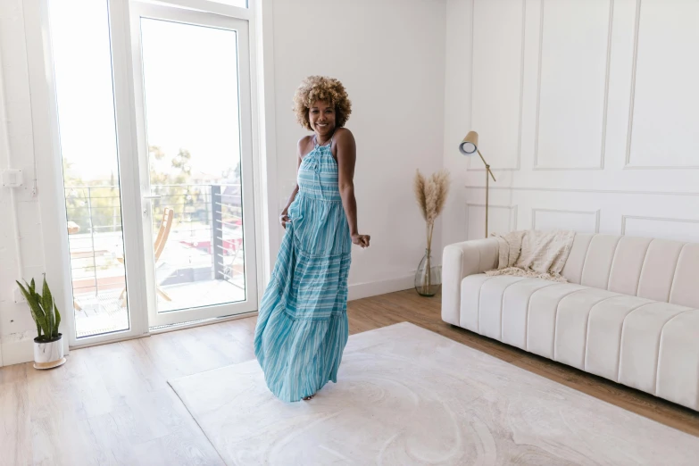 a woman in a blue dress is standing in the middle of a room